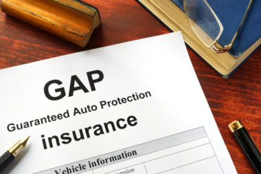 A document laying on a table that is labeled "GAP, guaranteed auto protection, insurance."