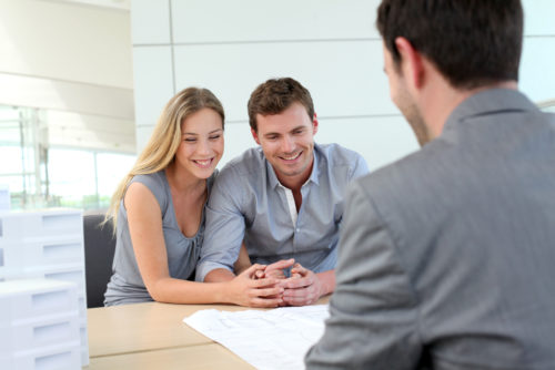 A couple speaking to an employee at a credit union.