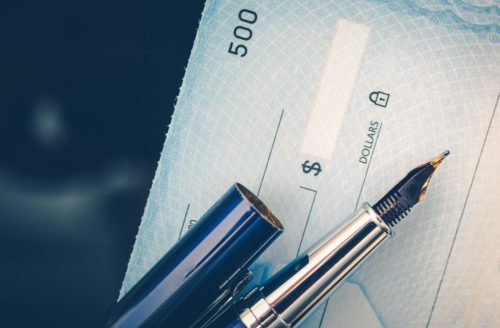 A fountain pen sitting on top of a check.