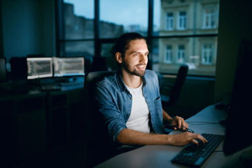 A software engineering manager working on a computer at his office.