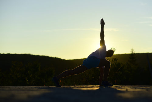 A man practicing preventative life maintenance in the form of yoga.