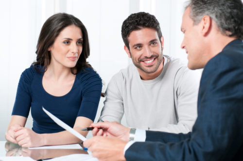 A credit union representative speaking to a couple about opening an account.