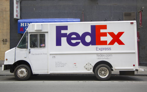 A Fed Ex Express truck parked on the side of a street.