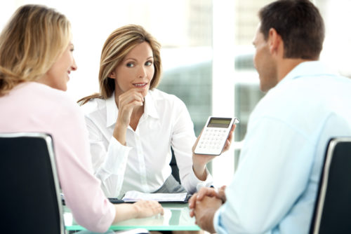 A couple speaking to a credit union representative about opening an account.