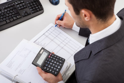 A man sitting at his desk, calculating alternative minimum tax.