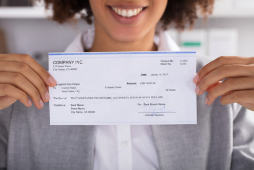 A closeup of a woman holding a check.