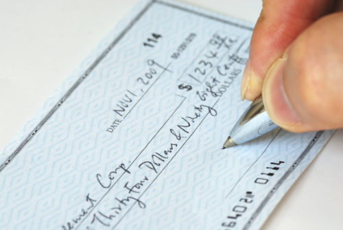 A man filling out a check.