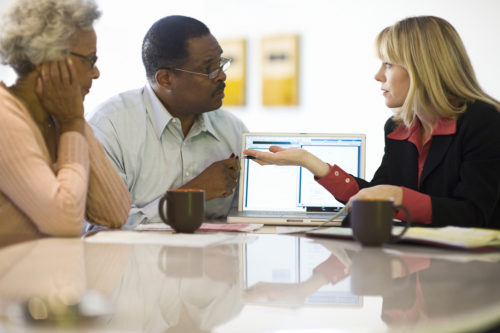 A financial advisor assisting a couple at their home.