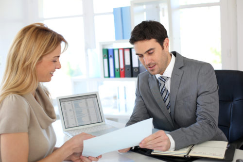 A banker going over a document with a customer.