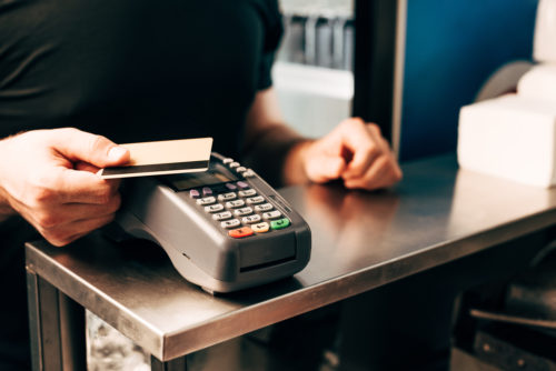 A man using his credit card at a pay terminal.