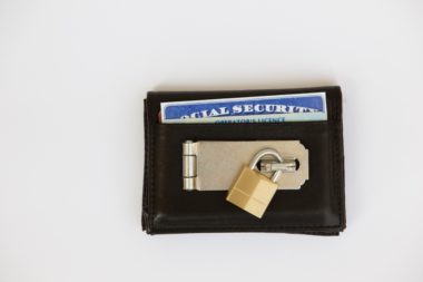 A wallet with a social security card sticking out has been padlocked.