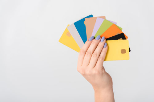 9 different credit cards fanned out in a woman's hand.