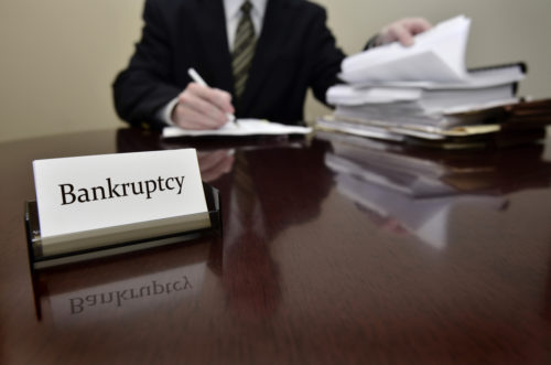 A bankruptcy accountant sitting at a desk with files and papers.