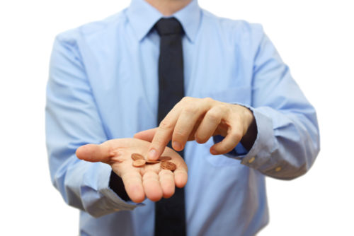 A business employee holds pennies in his hand.