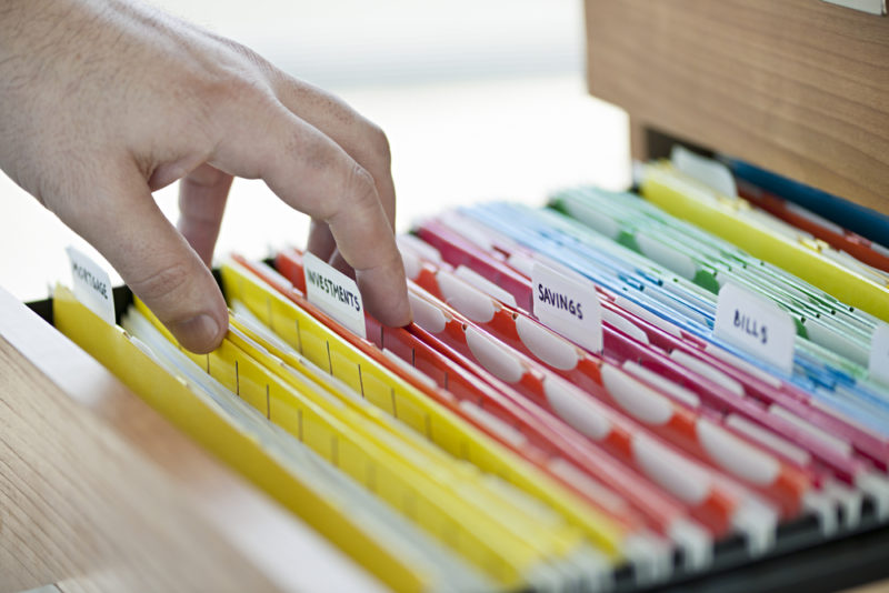 A man thumbing through documents in his file cabinet.