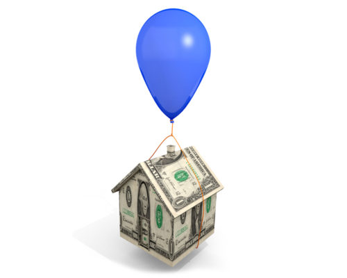 A conceptual image of a balloon tied to a tiny model house made out of money.