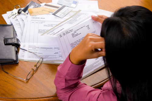 A woman looking over statements of her closed end credit loans.