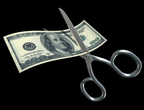 A graphic of a $100 bill being cut by a pair of scissors.