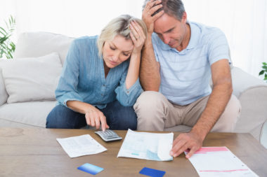 A couple worried about retirement look over financial documents.
