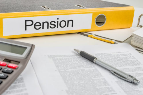 A notebook labeled "pension" lies next to a calculator and pen.
