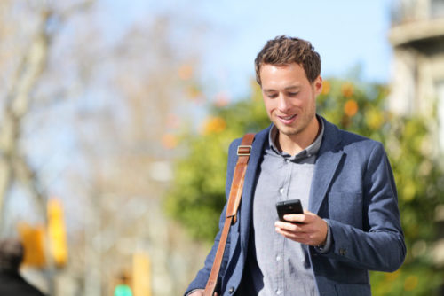 A young professional using an app on his smartphone.