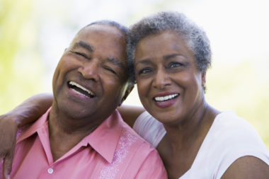 A retired couple hugging and smiling.