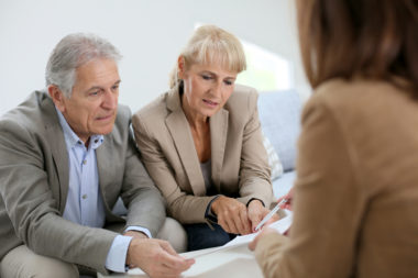 A senior couple speaking to a real estate agent.
