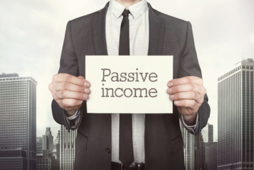 A businessman holding a sign that reads "passive income."