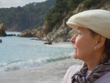 A woman, sitting at a beach and thinking about retirement.