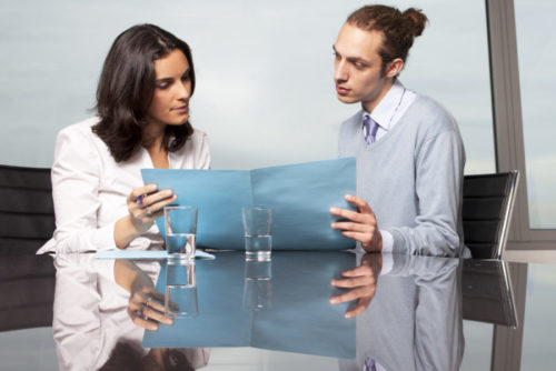 A young man speaks with a credit representative.