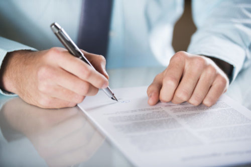 A businessman signing a document.