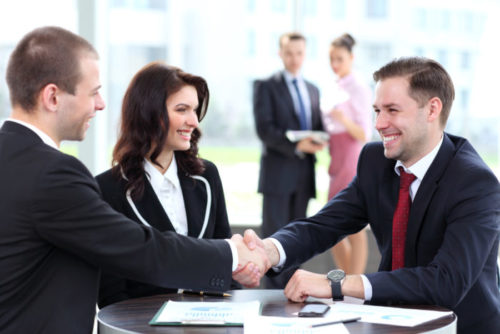 A couple of bank representatives greeting a client.