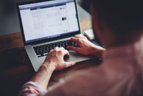 A man surfing the web on his laptop.