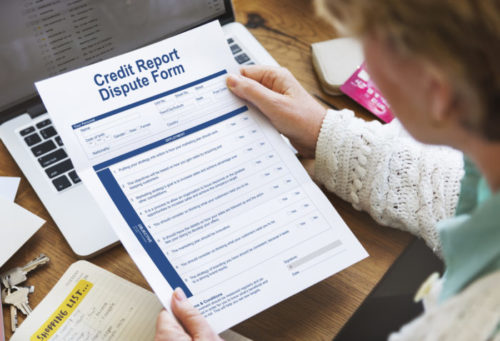A woman holding a credit report dispute form.