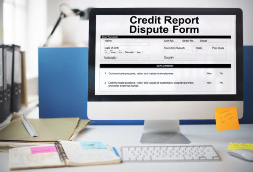 A computer's screen displays a credit report dispute form.