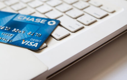 A Chase credit card lies on top of the keyboard of a laptop.
