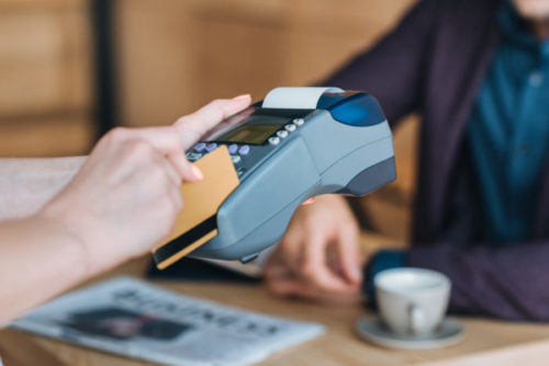 A credit card being swiped through a payment terminal.