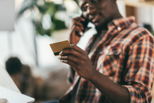 A man reading off his credit card information over the phone.