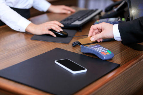 A man swiping his credit card through a payment terminal.