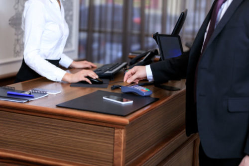 A man paying with a credit card at a hotel.