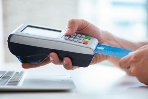 A man placing his credit card in a payment terminal.