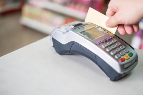 A credit card being swiped through a payment terminal.