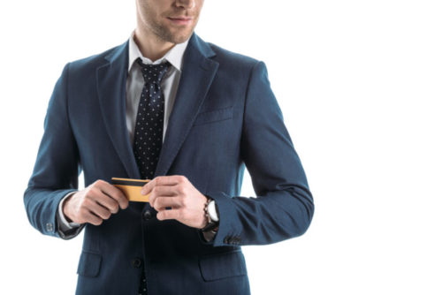 A businessman holds his credit card.