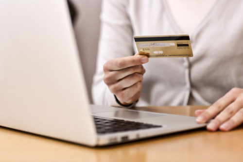 A woman shopping online reading her credit card information.