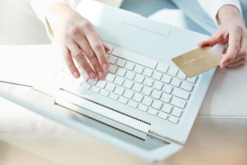 A woman using her credit card to make an online purchase.