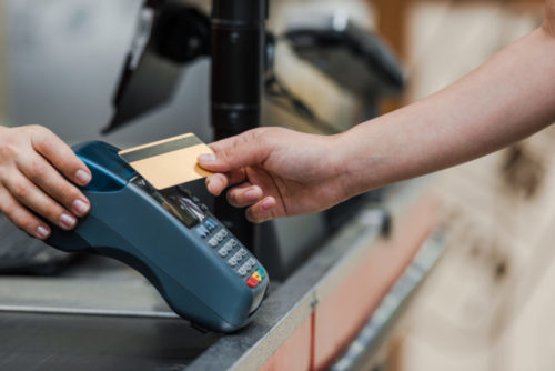 A man paying with a credit card at a supermarket.