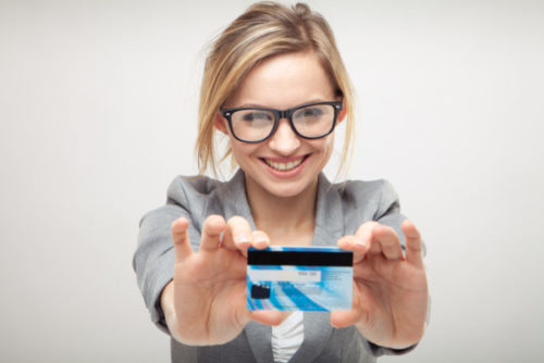 A woman holding up a credit card with both hands.