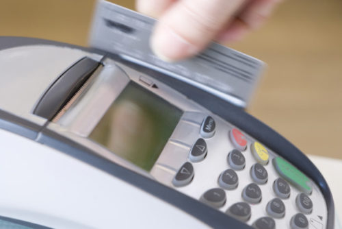 A credit card being swiped through a payment terminal.