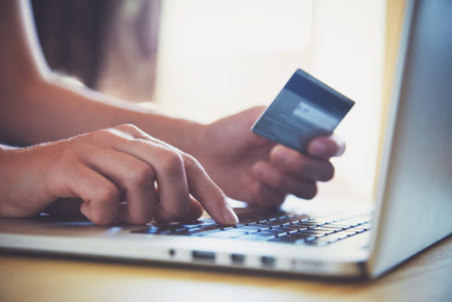 An online shopper typing in their credit card information on their laptop.