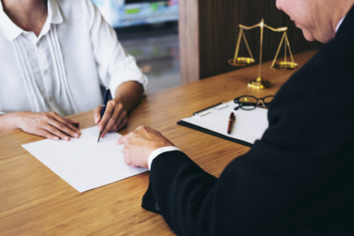 A person signing a document handed to them by a credit repair consultant.